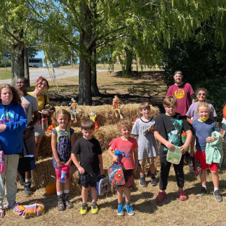 therapeutic recreation participants young children standing in front of bales of hay