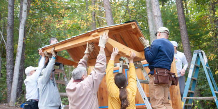 neighbors completing project and lifting roof of a kiosk