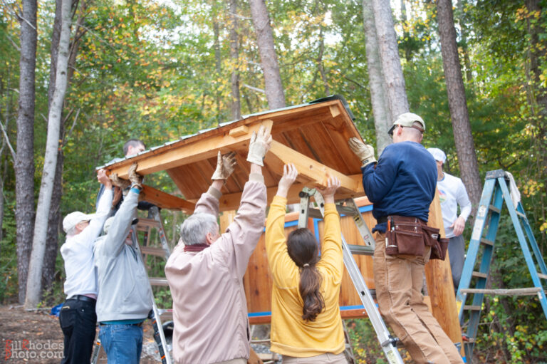 neighbors completing project and lifting roof of a kiosk