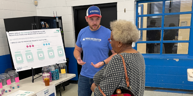 parks employee speaking to community member at event