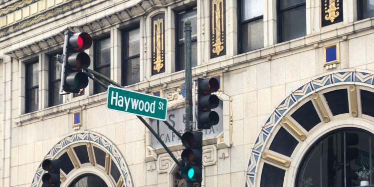 traffic signal with Haywood road sign with historic building in the background