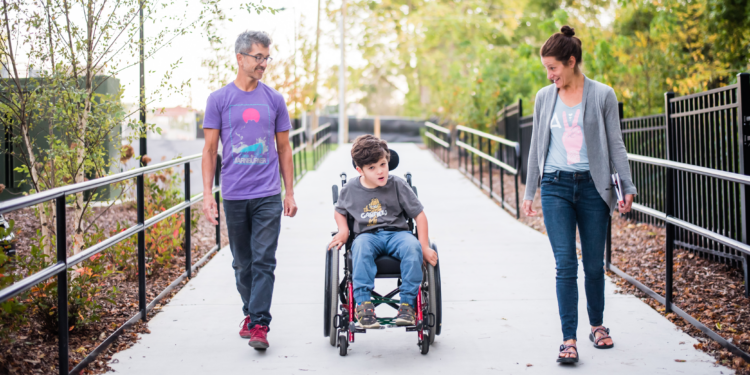 man, boy in wheelchair and woman on paved greenway