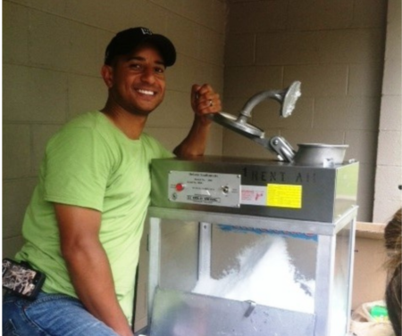 max cherry in green shirts making snow cones with the machine