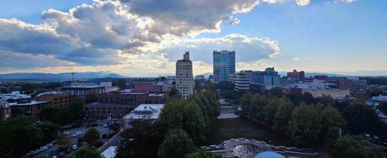 beauty shot of downtown Asheville shows downtown skyline against blue skies
