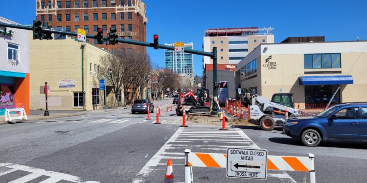 detour signs at pedestrian cross walks divert foot traffic as sidewalk works are carried out