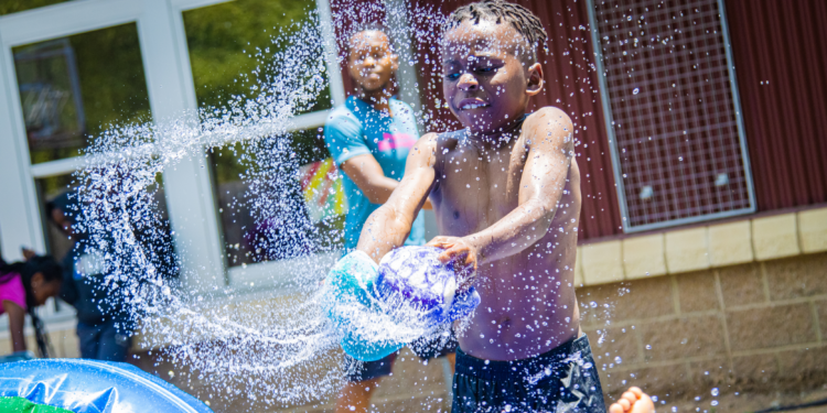 young boy playing with water toy