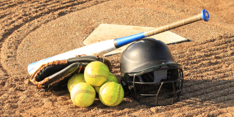 yellow baseballs, batting helmet and baseball bat laying on field