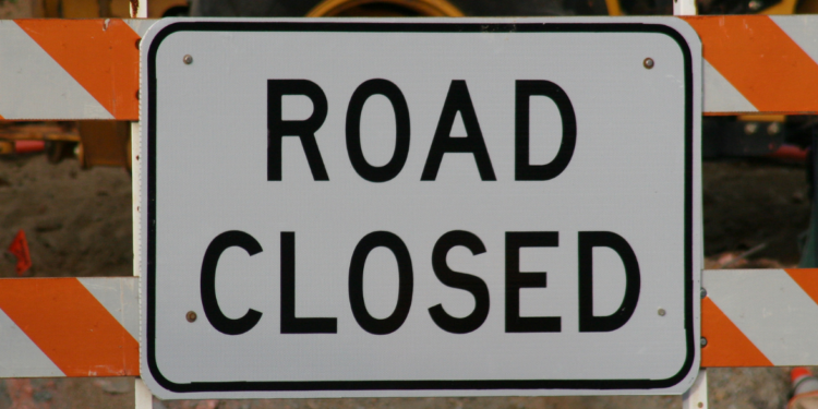 road closed sign with equipment in the background
