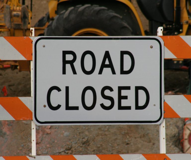 road closed sign with equipment in the background