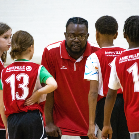 coach speaking with young basketball players