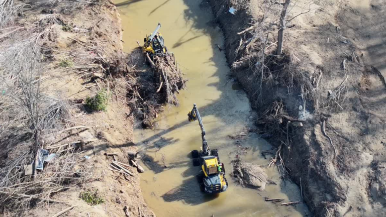 large equipment in waterway clearing debris