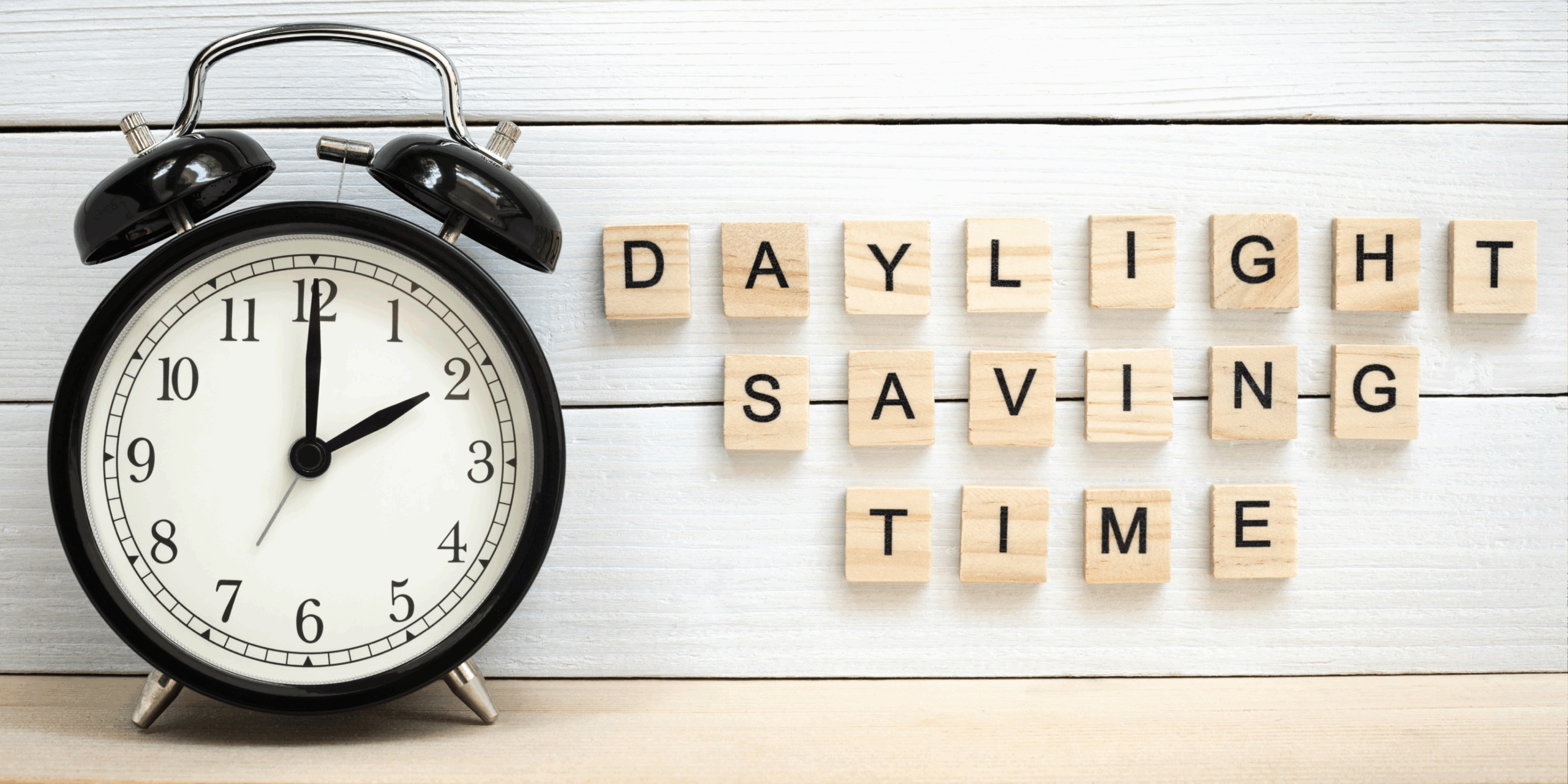 clock with daylight saving time spelled in scrabble tiles next to it