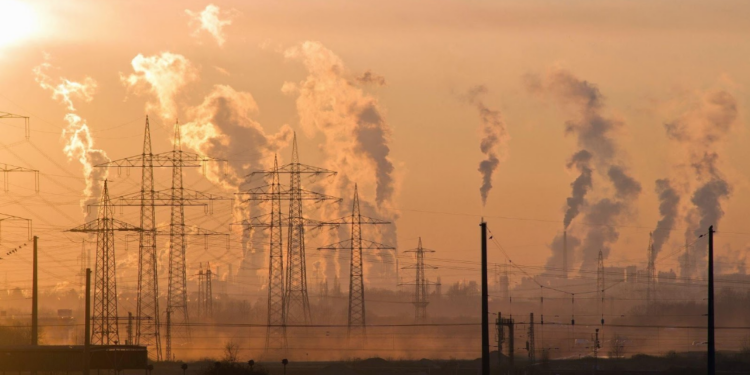 power lines with smokestacks in the background