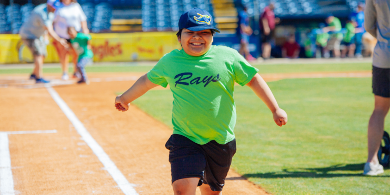 young boy wearing green shirt playing baseball