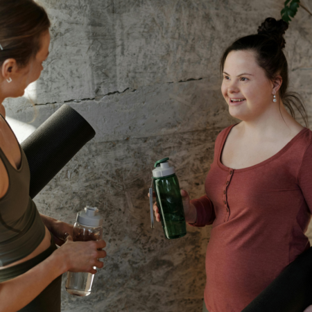 young woman holding water bottle as if after exercise