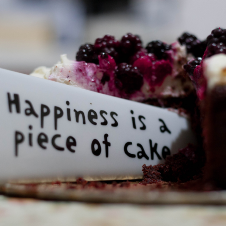berry topped cake with label 'happiness is a piece of cake'