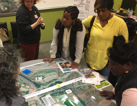 people gathered round site plan for recreation phase of grant center