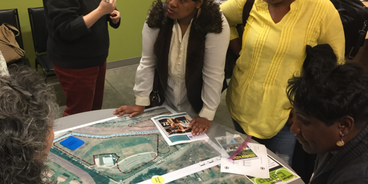 people gathered round site plan for recreation phase of grant center
