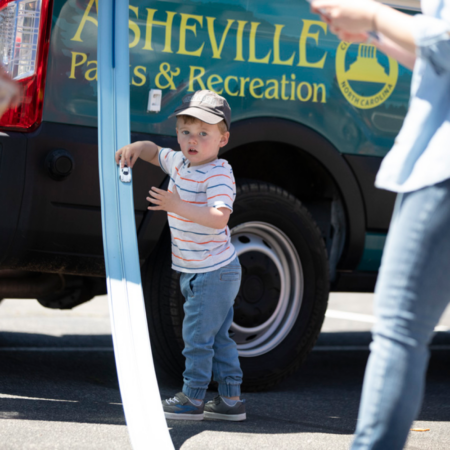 young boy with toy car on race track