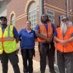 art drivers standing together with safety vests on