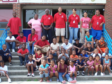 staff and children sitting on steps at the Reid Center