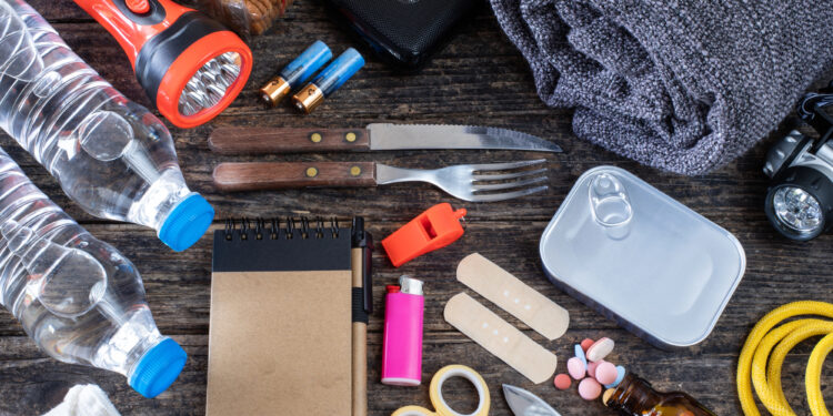 contents of emergency preparedness kit including water, flashlight, batteries, blanket, medicine, utensils