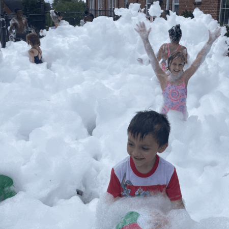 young boy and girl playing in a mountain of foam