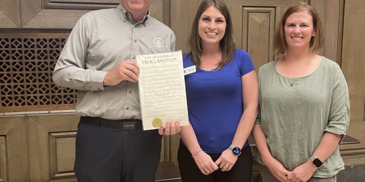 WNC director Chris Gentile and Friends of WNC NAture Center members hold proclamation in council chambers
