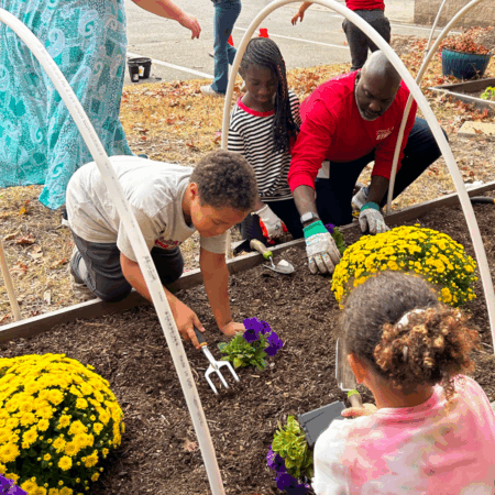 children planting flowers in community garden