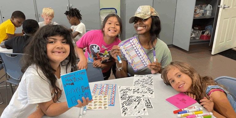4 young girls doing arts and crafts at a table
