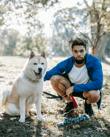 large white dog on leash with african american man