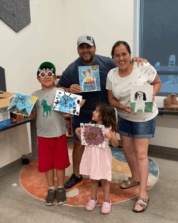 4 family members holding painting from family paint night