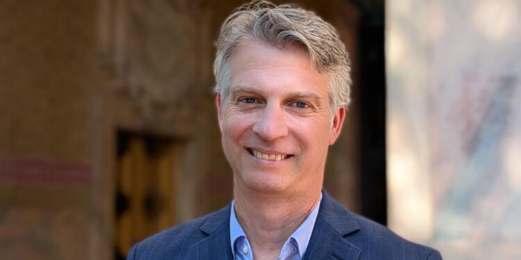 Jade in front of City hall with a blue suit and shirt on