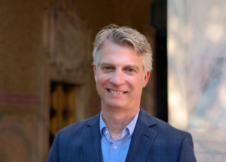 Jade in front of City hall with a blue suit and shirt on