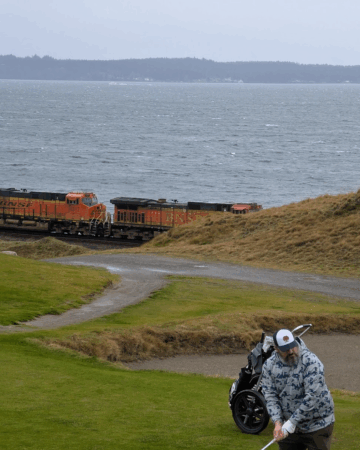 Brandon Reese plays golf near lake and train track
