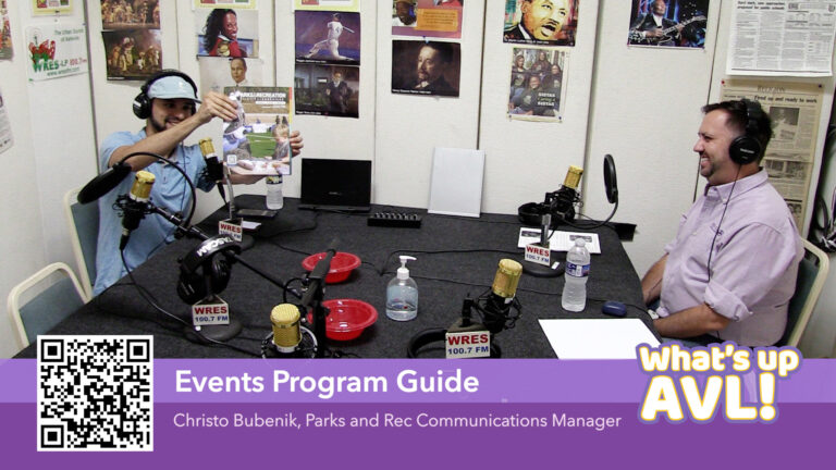 Sam and Christo in studio. Sam holding the Fall programming guide cover up for the camera. Christo smiling