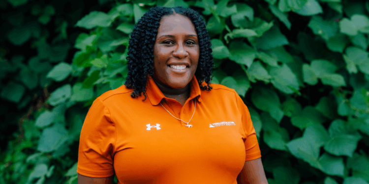 Anice Smith wears an orange Parks and Recreation polo shirt