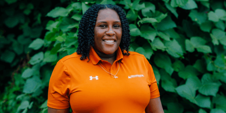 Anice Smith wears an orange Parks and Recreation polo shirt