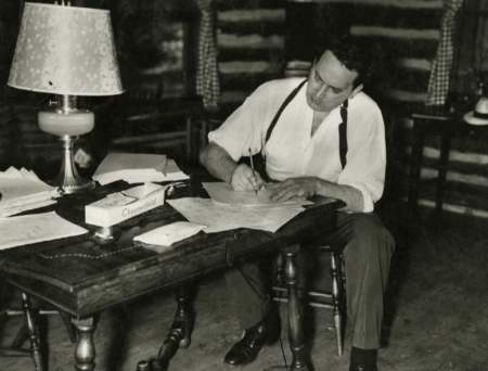 author Thomas Wolfe sits at a desk writing