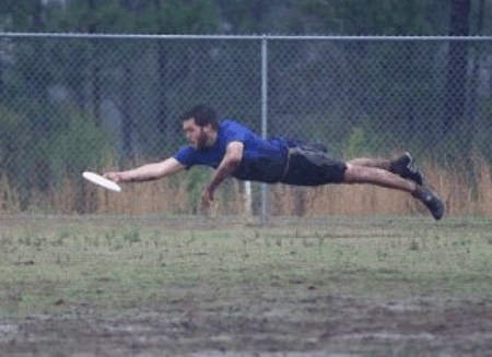 diving for a frisbee over muddy field