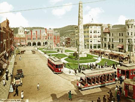 This 1910 scene of the square captures a transformational period for the city with trolley cars, automobiles, and horse-drawn carts, as well as several community members.
