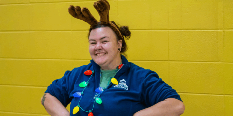 Fallon Hyder wears Christmas light necklace, reindeer antlers and blue Parks & Recreation jacket