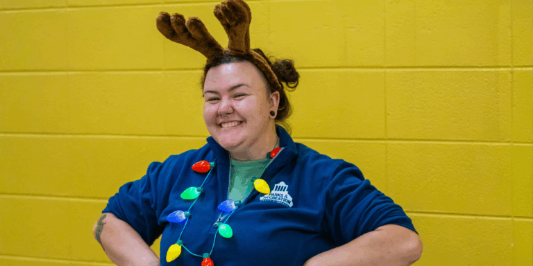 Fallon Hyder wears Christmas light necklace, reindeer antlers and blue Parks & Recreation jacket