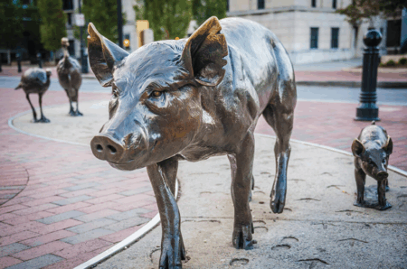 urban trail art featuring bronze pig and piglets