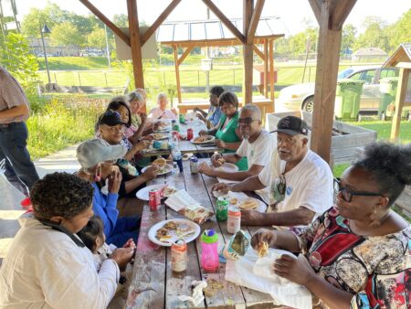 Neighborhood matching grant participants at a picnic table for a shared meal
