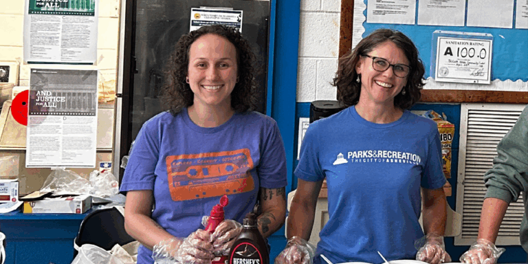 Summer Diemer and Christy Bass serve ice cream wearing blue parks and recreation tshirts