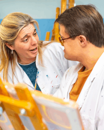 young man paints on a canvas