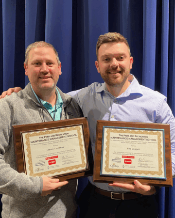 Eric Daggett holds certificate for Parks Maintenance Management School