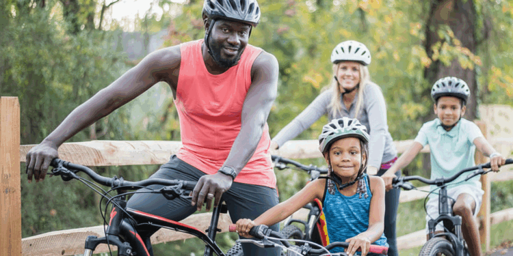 family of 4 rides bikes on greenway