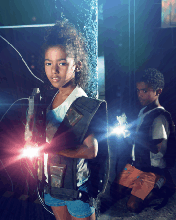 young girl and boy wear laser tag vests and hold laser guns